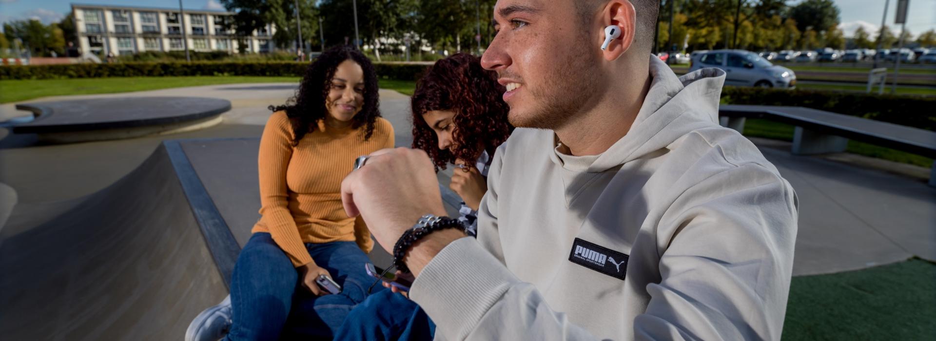 3 jongeren zittend op een bank bij de skatebaan in Almere Stad